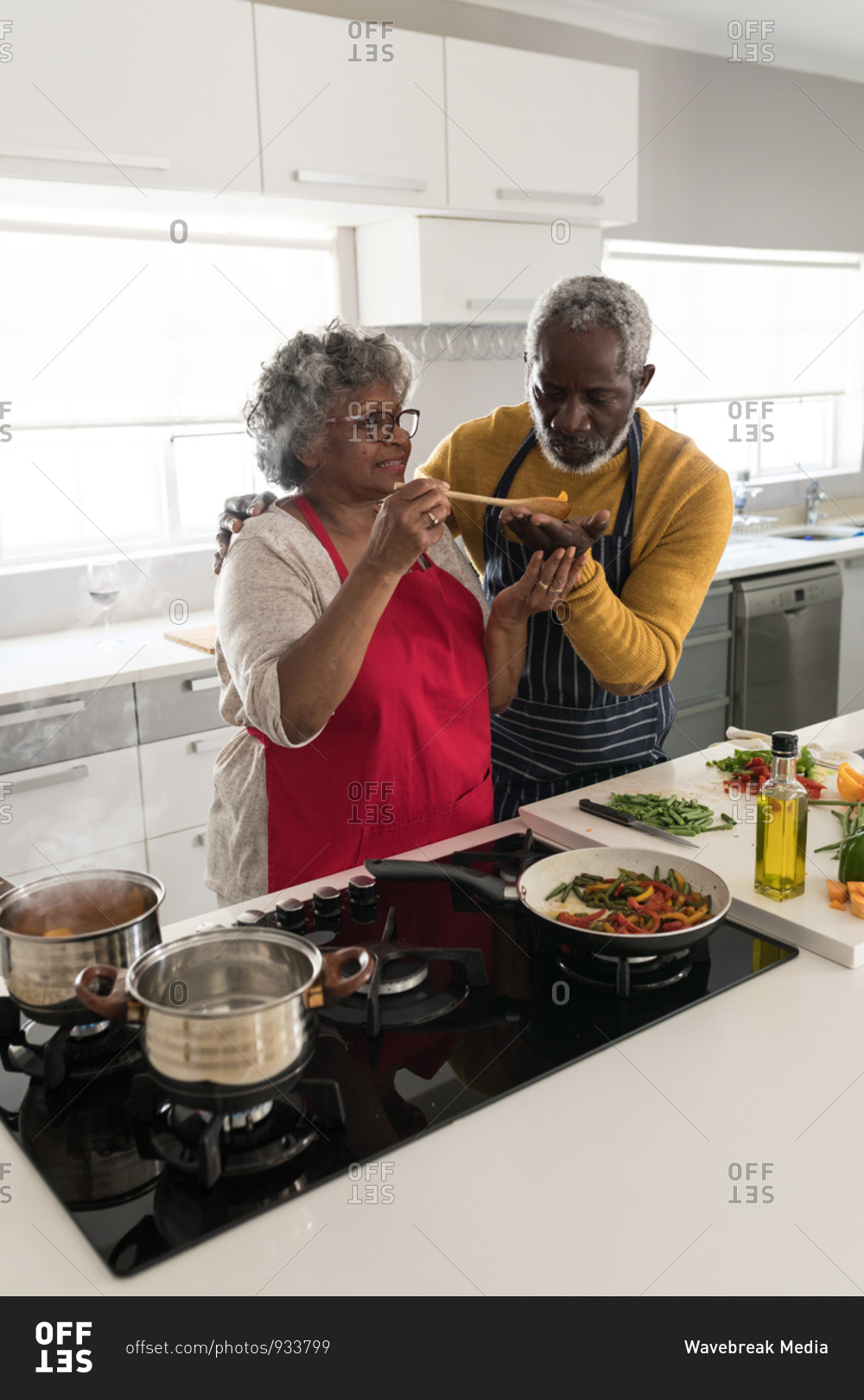 A senior African American couple spending time at home together, social distancing and self isolation in quarantine lockdown during coronavirus covid 19 epidemic, standing in the kitchen preparing food