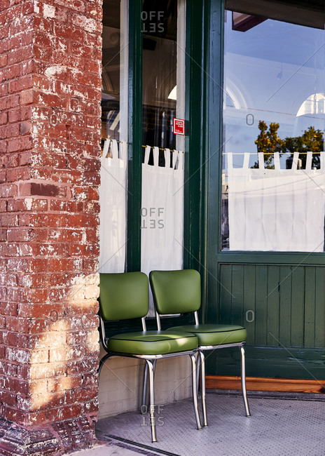 Charleston, South Carolina, USA - September 7, 2018: Green chairs outside of a green and brick building