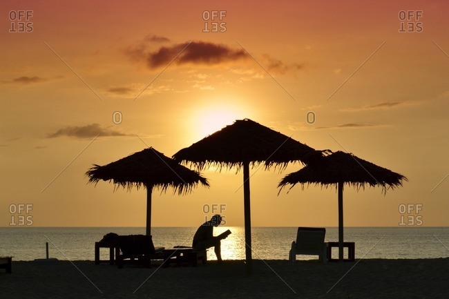 Person reading book on the beach at sunset, silhouette, Kib Hotel, Koh Kho Khao Island, Southern Thailand, Southeast Asia