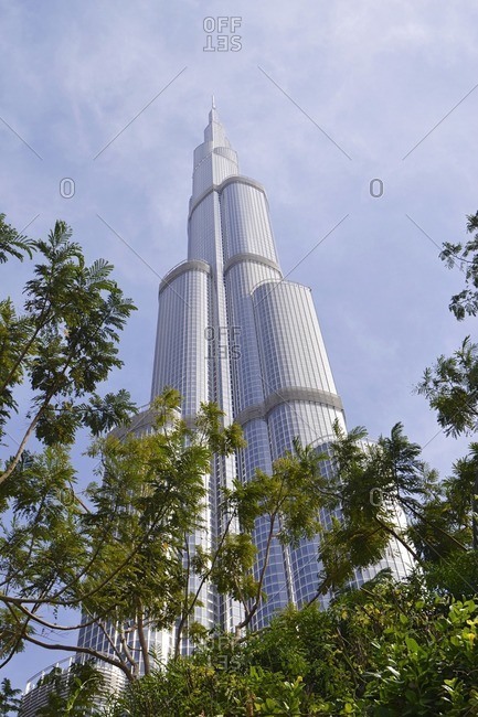 February 15, 2012: Burj Khalifa in front of blue sky, exotic flowers, architecture, Dubai Business Bay, Emirate of Dubai, United Arab Emirates, Arabian Peninsula, Middle East