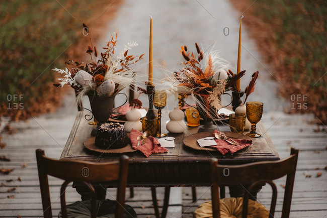 Rustic table set with fall decorations and dessert outdoors