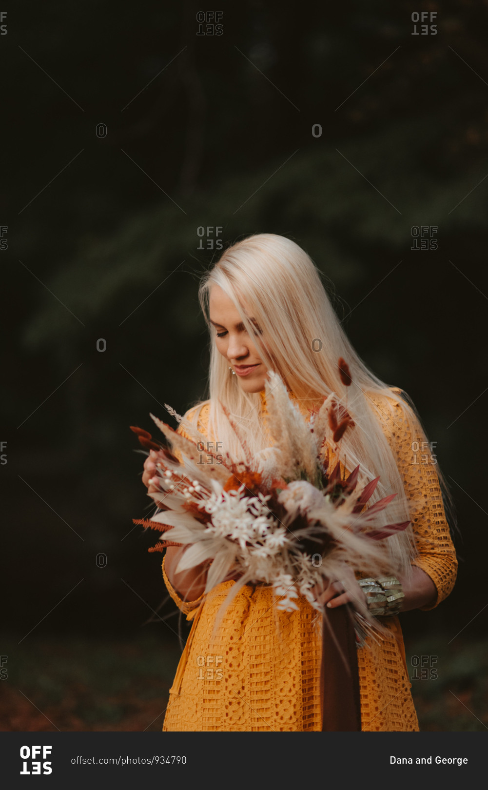 Beautiful blonde bride holding fall wedding bouquet