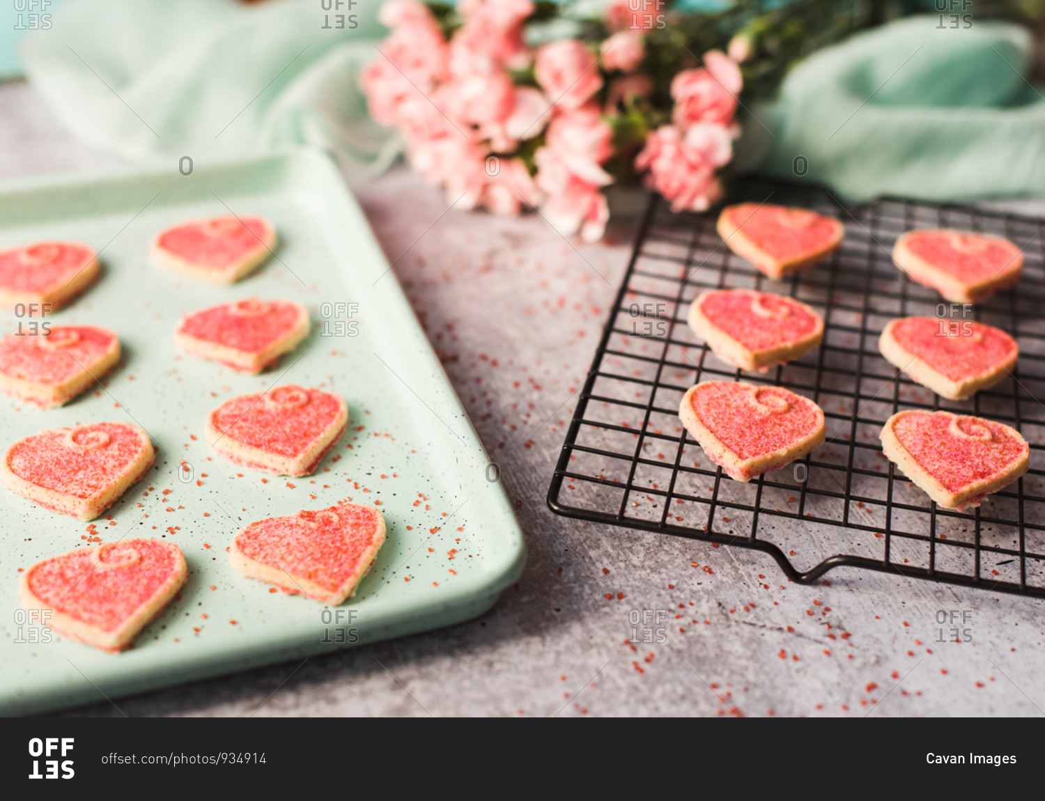 Close up of Valentine's day heart cookies cooling on a pan and rack.