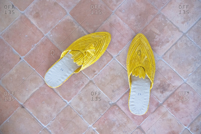 Yellow slippers on a brick floor