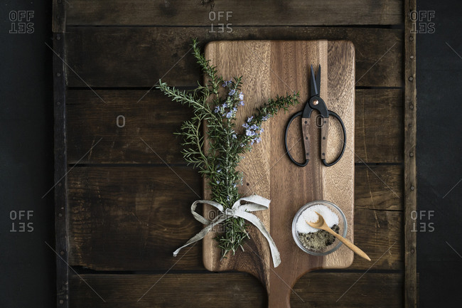 Bundle of fresh rosemary, coarse salt, scissors on cutting boards