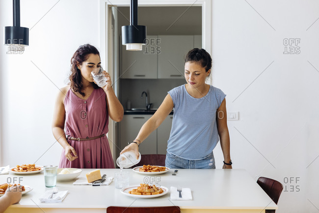 Women serving meal spending time at home together