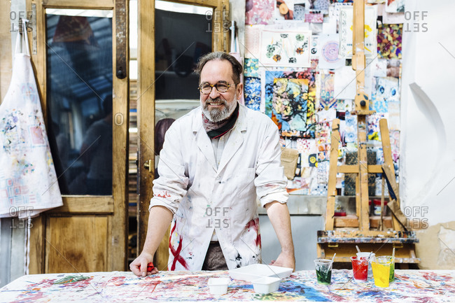 Cheerful mature artisan in textile workshop