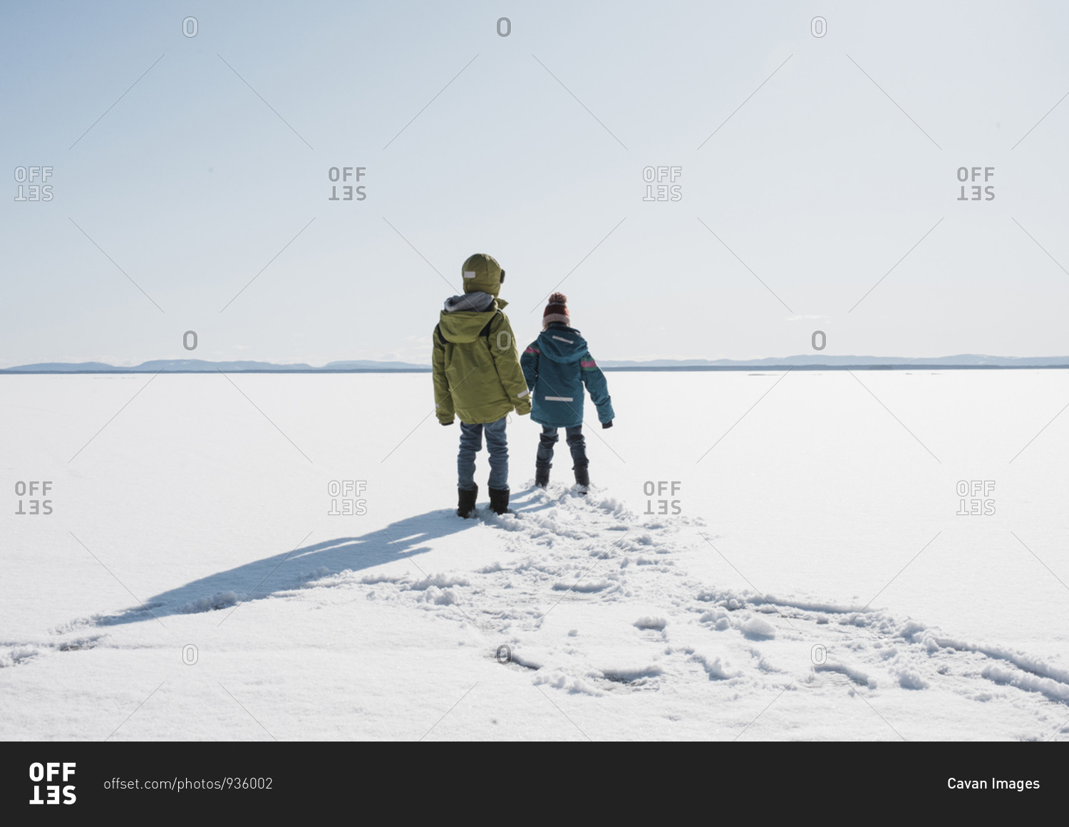 Kids walking across a frozen lake in Sweden