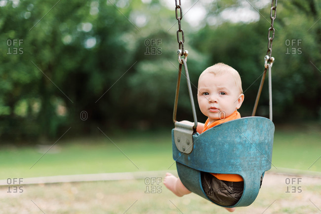 Little six month old boy in a swing for the first time.