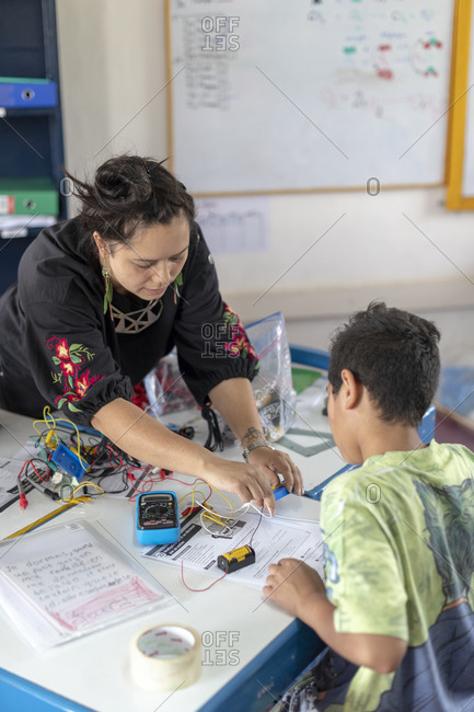 Kathmandu, Nepal - March 4, 2019: A teacher in a school in Kathmandu helps students with their work in a science and technology class