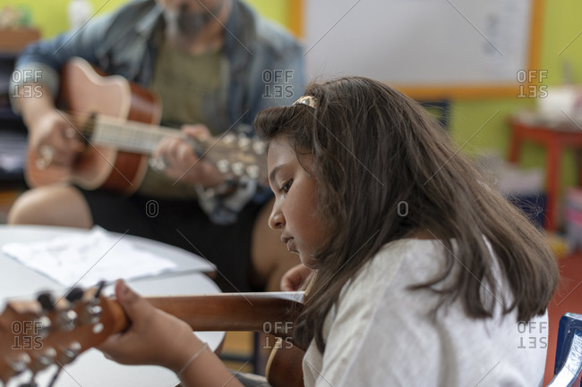 Kathmandu, Nepal - March 4, 2019: A girl plays the guitar in a music lesson in a school in Kathmandu