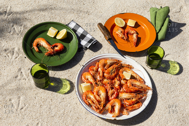 Cooked shrimp on plates in beachy setting