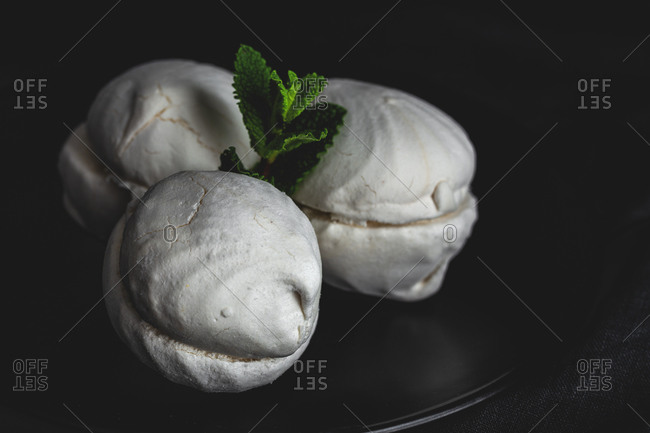 From above homemade white Zefir or Zephyr, Russian traditional dessert with mint on black background