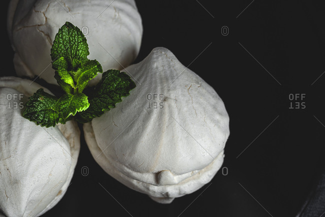 From above homemade white Zefir or Zephyr, Russian traditional dessert with mint on black background