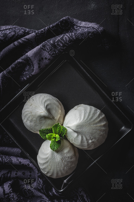 From above homemade white Zefir or Zephyr, Russian traditional dessert with mint on black background