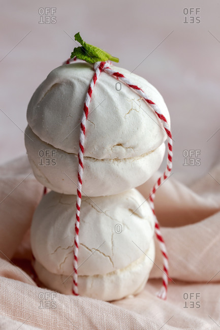 Homemade white Zefir traditional russian dessert hold by a small rope on pink background