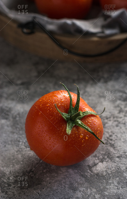 From above of wet clean tomatoes placed on gray fabric napkin on grey concrete table background