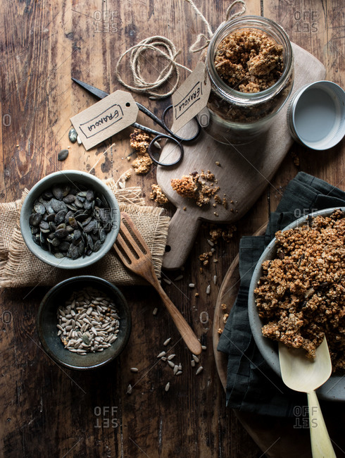 From above yummy millet and quinoa granola and fresh seeds placed on lumber table in kitchen