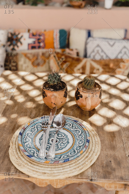 Morocco- Table with two potted cacti and cutlery lying on ornate plate