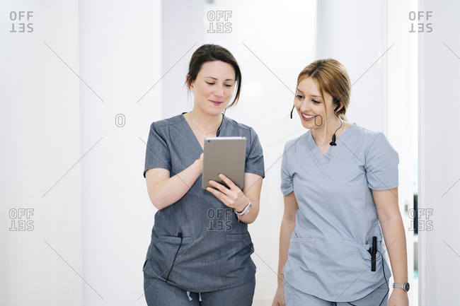 Two medical secretaries with headset and tablet in medical practice