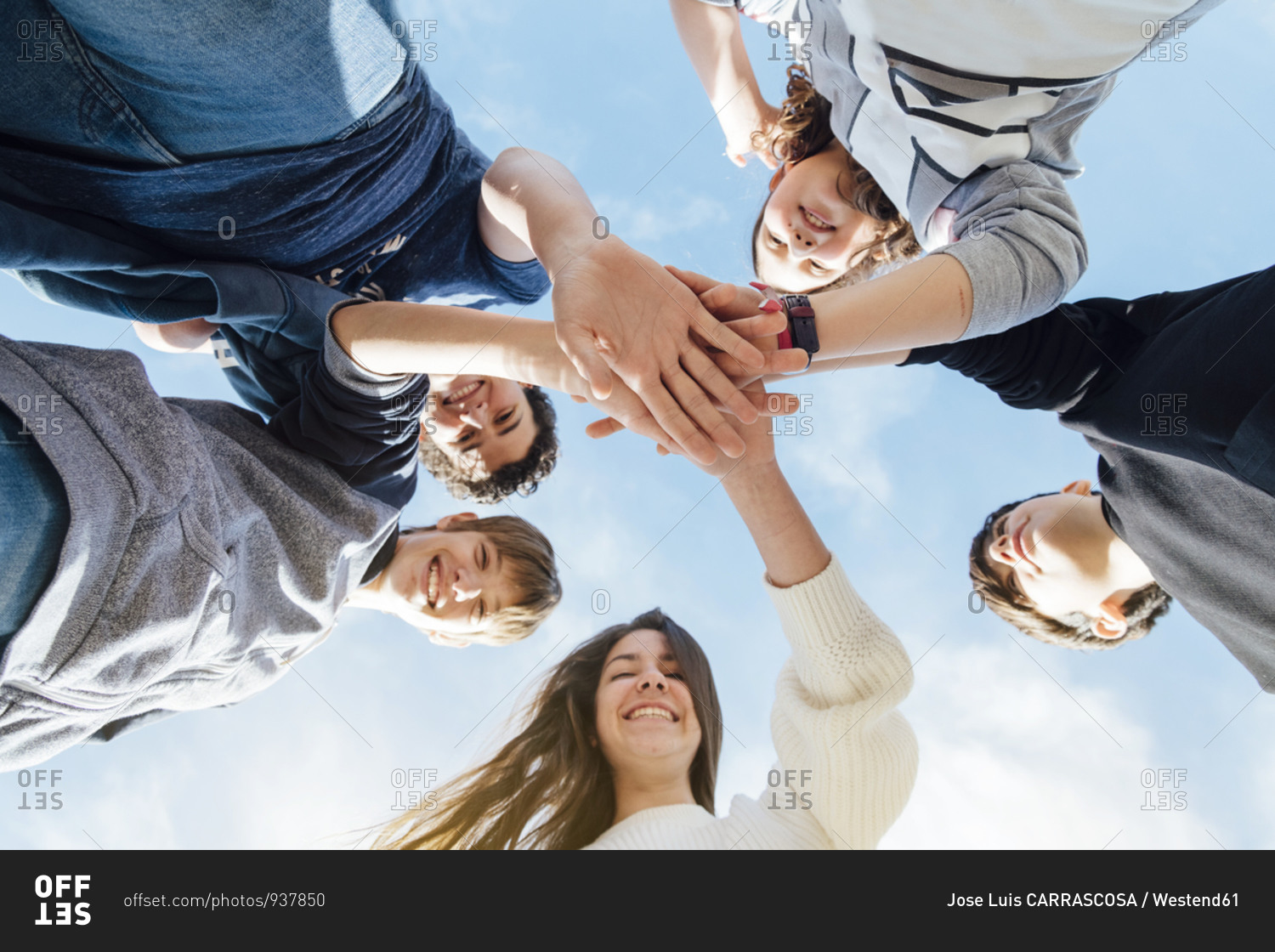 Five friends stacking their hands- seen from below