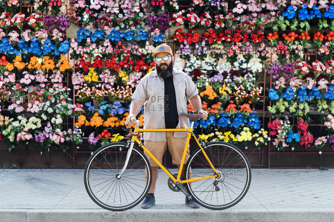 Portrait of bearded man with fixie bike wearing mirrored sunglasses