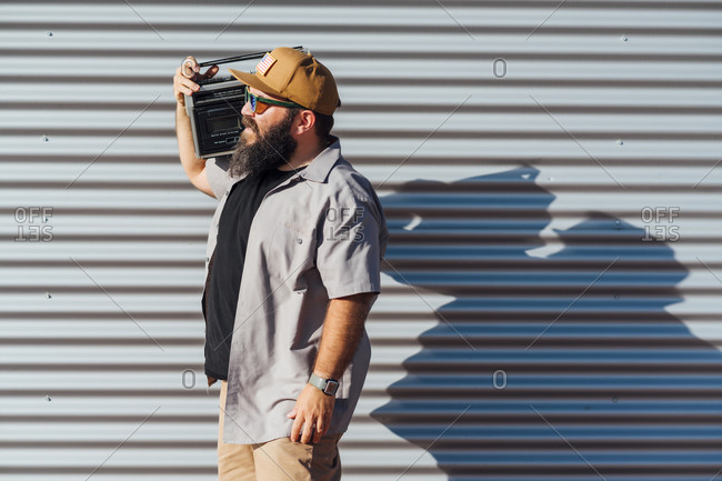 Bearded man carrying portable radio on his shoulder