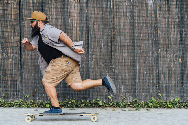 Mature hipster man skateboarding outdoors