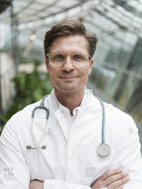 Portrait of doctor with stethoscope- standing in atrium