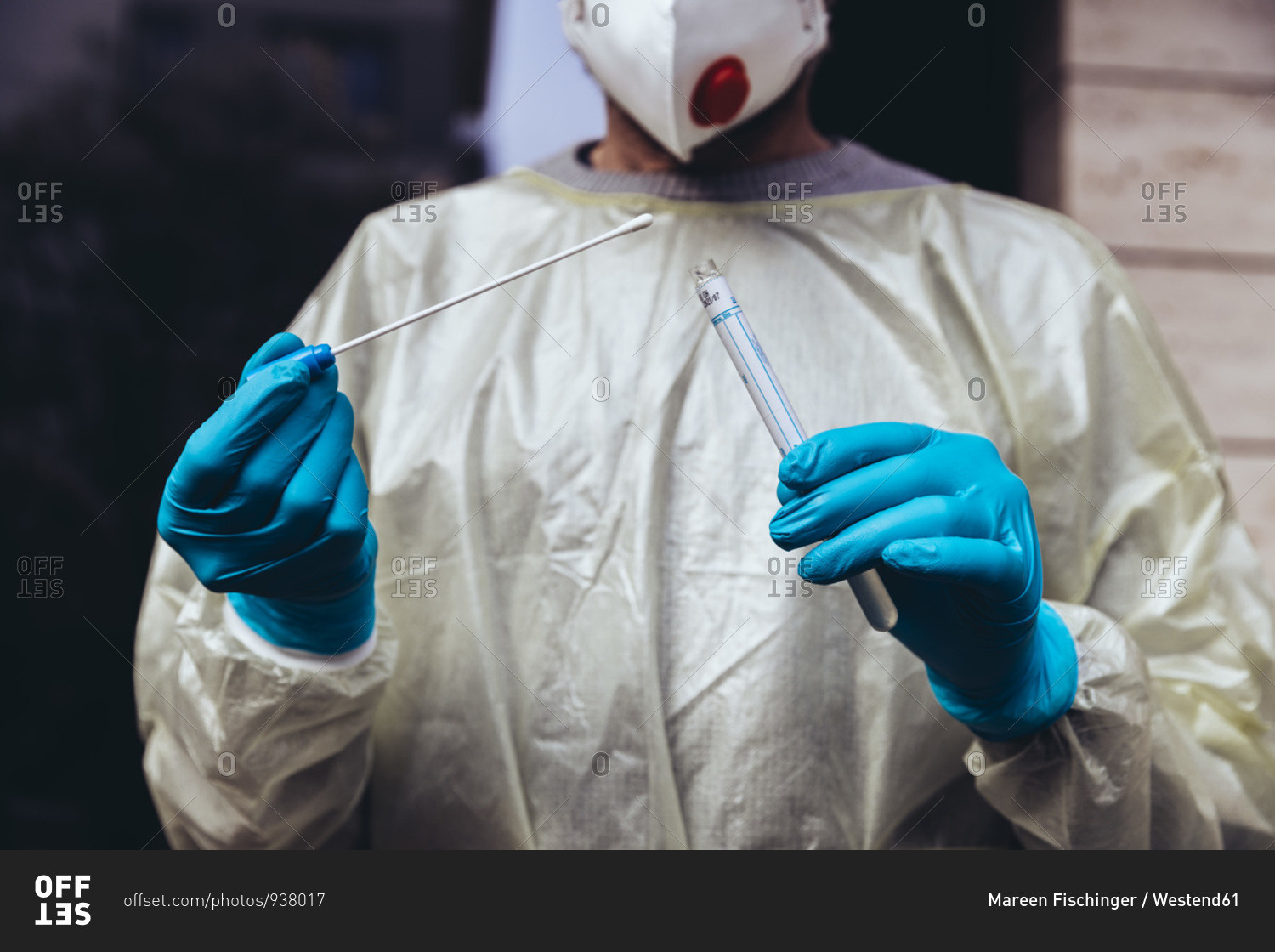 Healthcare worker holding swab test kit for PCR testing