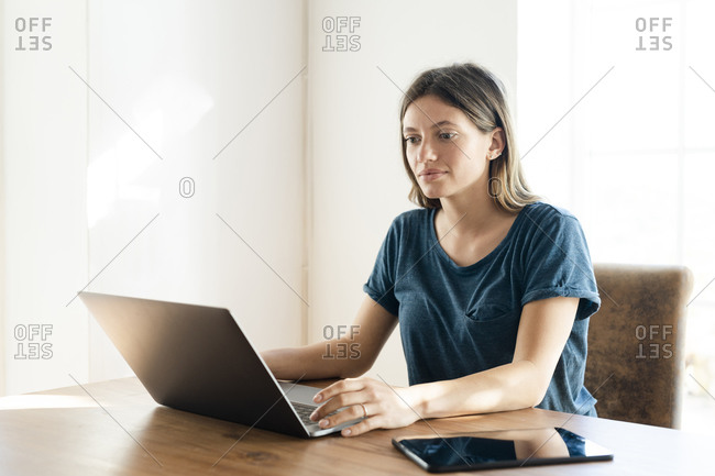 Young woman at home working on her laptop in home office