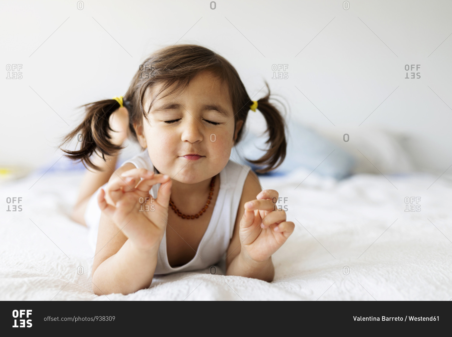 Portrait of little girl with eyes closed lying on bed at home stock ...