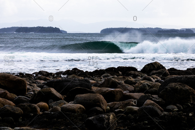 Large waves cresting as they roll into a rocky beach