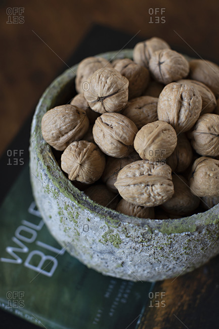 Whole walnuts in a green textured bowl