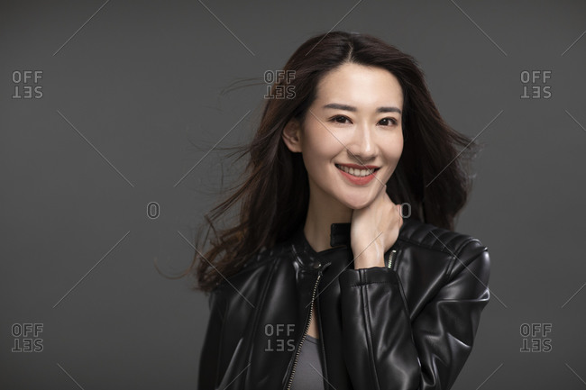Cool young Chinese woman wearing a black leather jacket stock