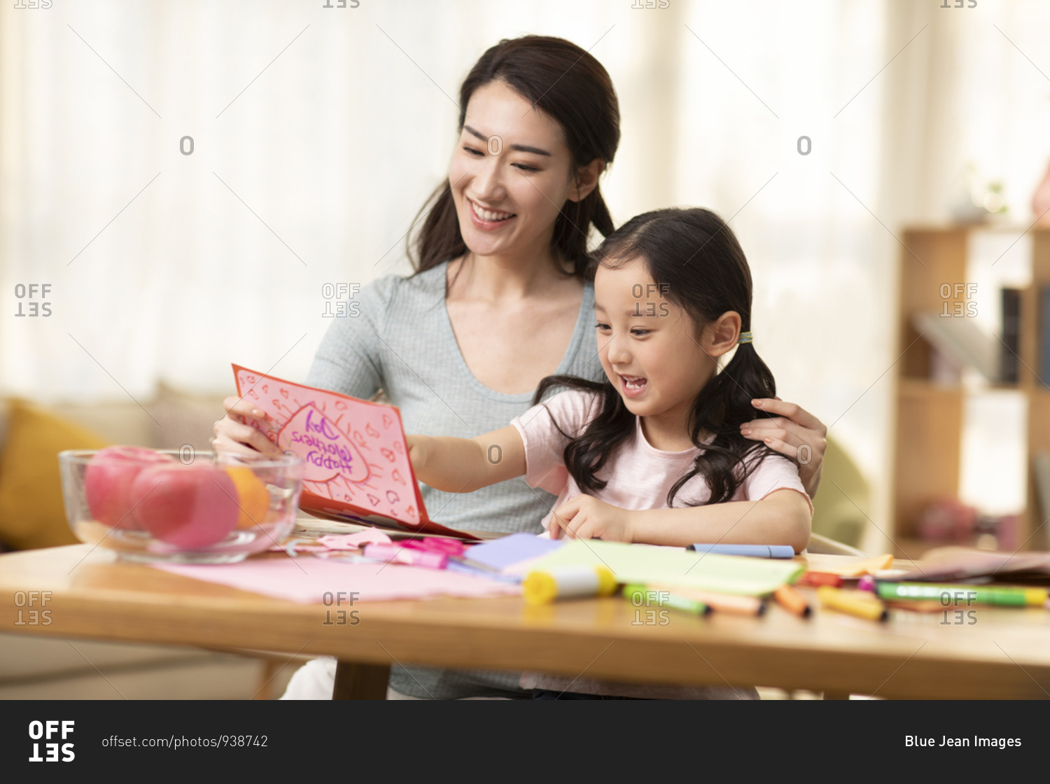 Little Chinese girl making greeting card for mother