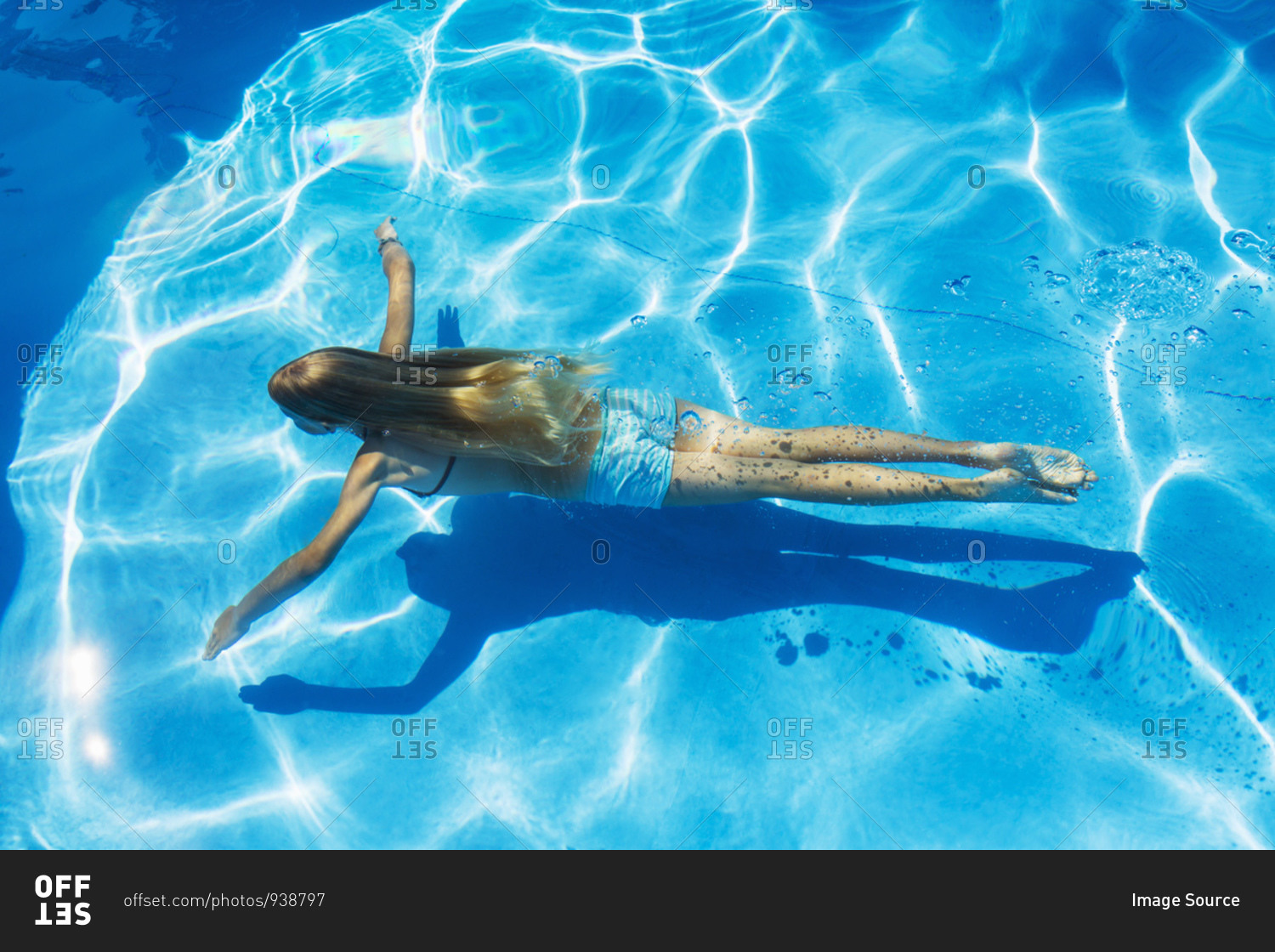 Girl swimming underwater in outdoor swimming pool, high angle view, Vernazza, Liguria, Italy