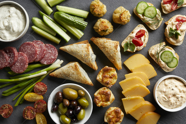 Appetizer snack spread with open sandwiches, olives and cheese , overhead view