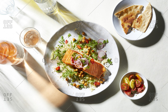 Plate of salmon and salad with pitta bread, overhead view