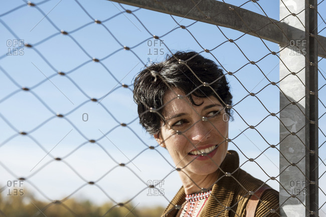 Smiling woman behind fence - Offset