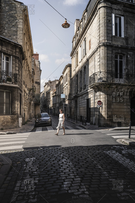 Street scene with woman crossing road, Bordeaux, Aquitaine, France