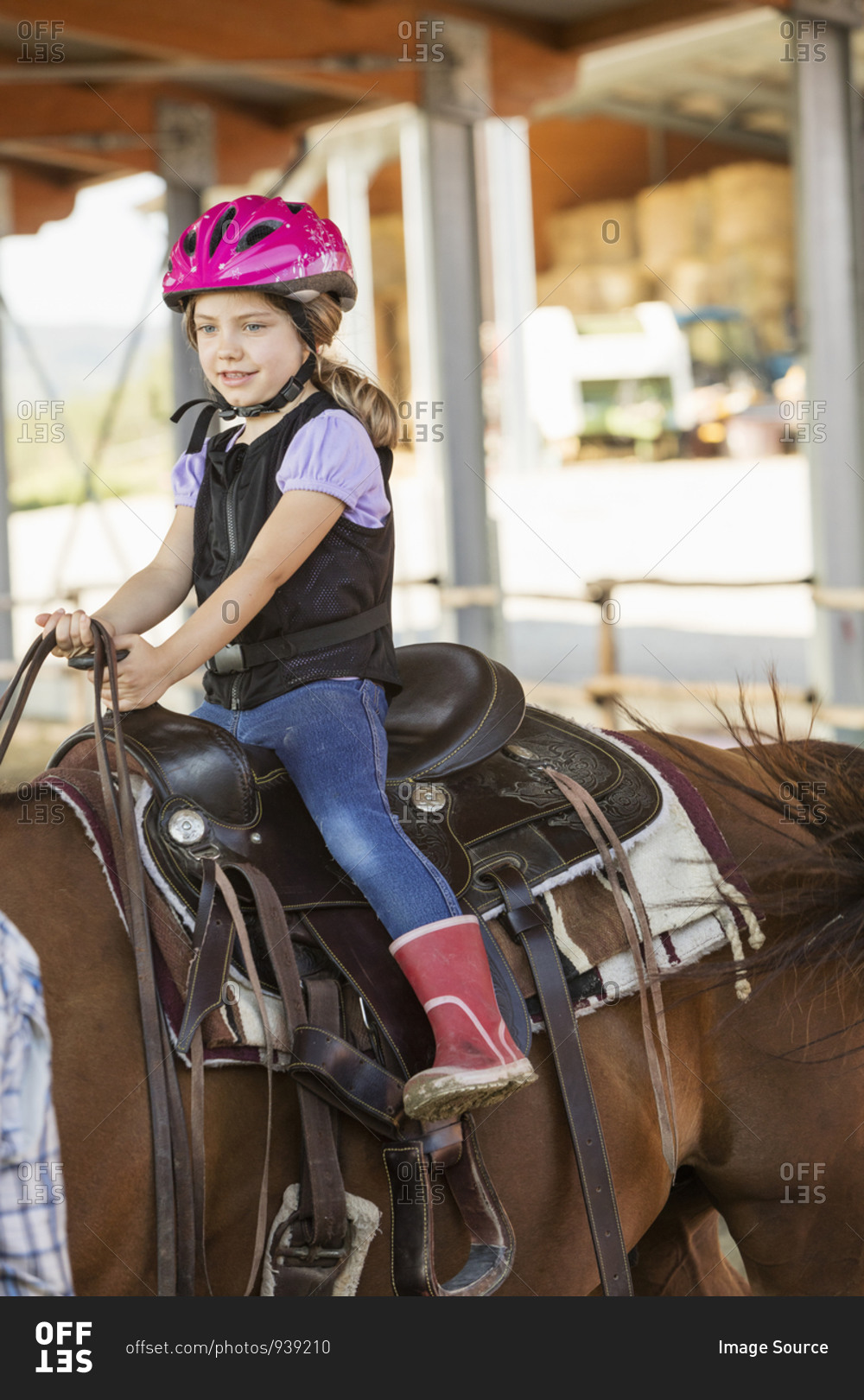 Girl horse riding in equestrian arena