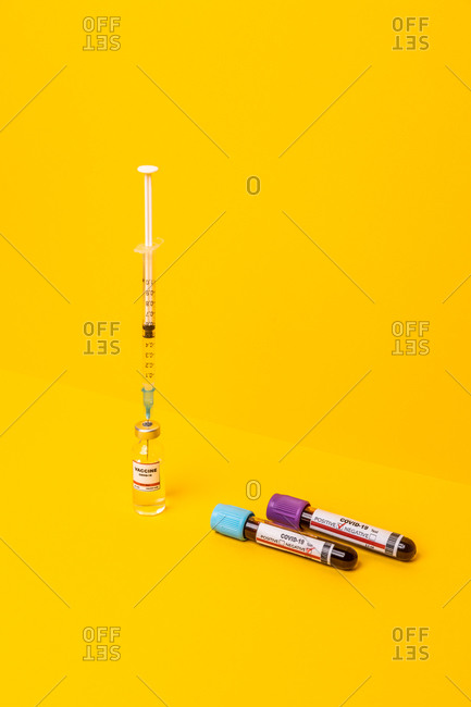 Coronavirus progress with the vaccine, positive and negative tests. yellow background. high angle of view.
