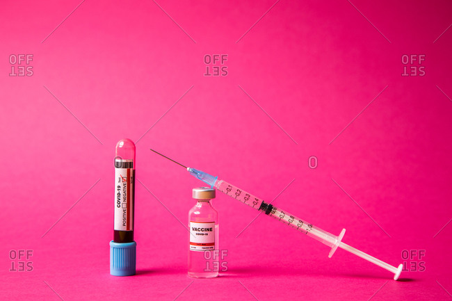 Coronavirus progress with the vaccine, positive and negative tests. pink background. high angle of view.