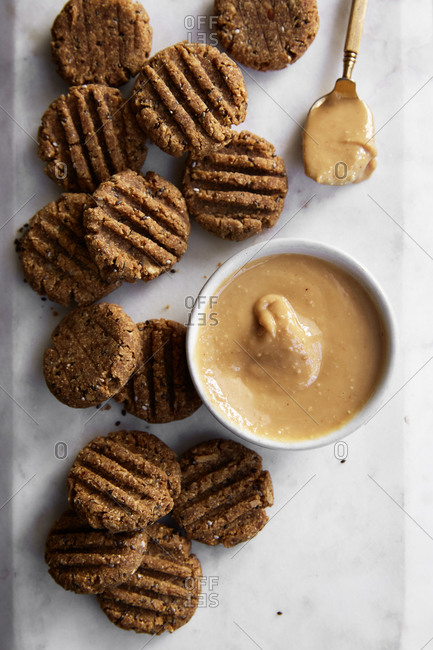 Homemade peanut butter cookies on a marble serving platter with extra peanut butter,