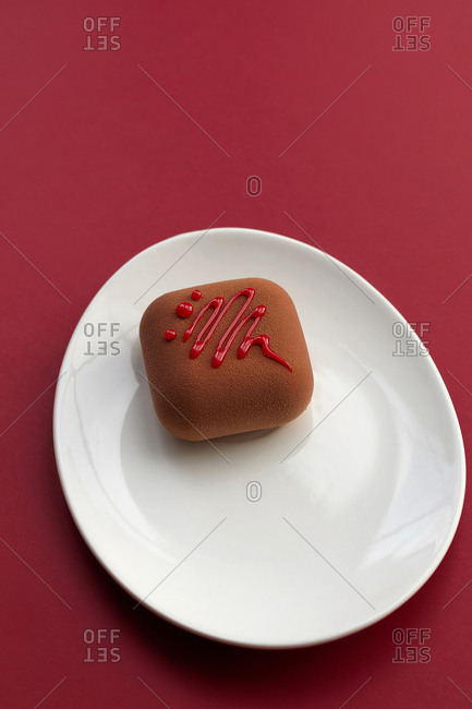 dessert mousse cake on a white plate on a red background Breakfast on the table minimalism