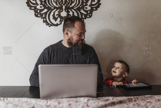 Work at home father working with young toddler during isolation