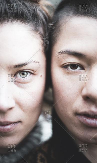 Split face double portrait of beautiful gay women mixed race couple