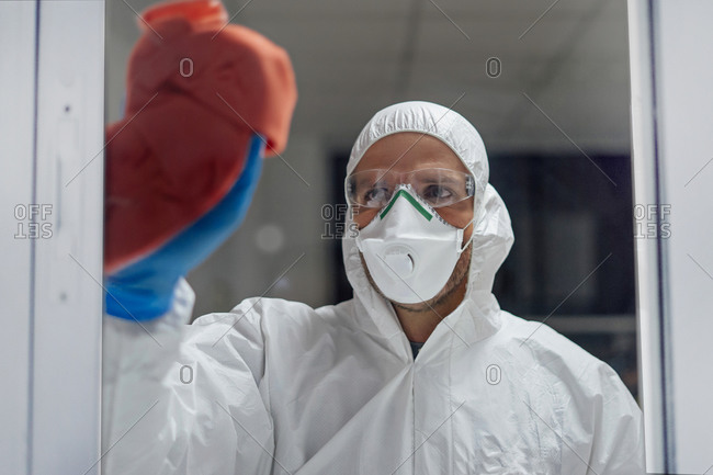 Cleaning staff disinfecting hospital against contagious virus- wearing protective clothing