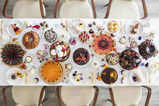 Directly above view of dining table filled with all kinds of snacks and desserts